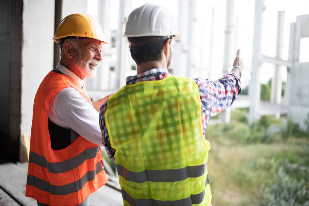 istock Confident team of architects and engineers working together on construction site 1143269237