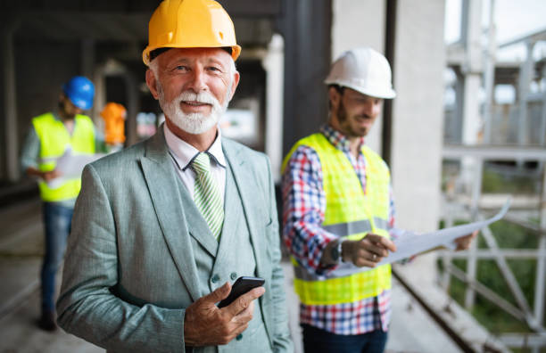 istock Confident team of architects and engineers working together on construction site 1143269238