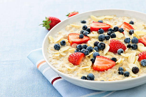 istock Oatmeal breakfast cereal with berries and almonds on linen 114326996