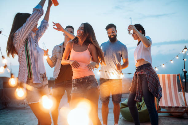 istock Group of happy young friends having party on rooftop 1143270068