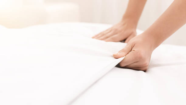 istock Young woman making bed and organizing room 1143271706