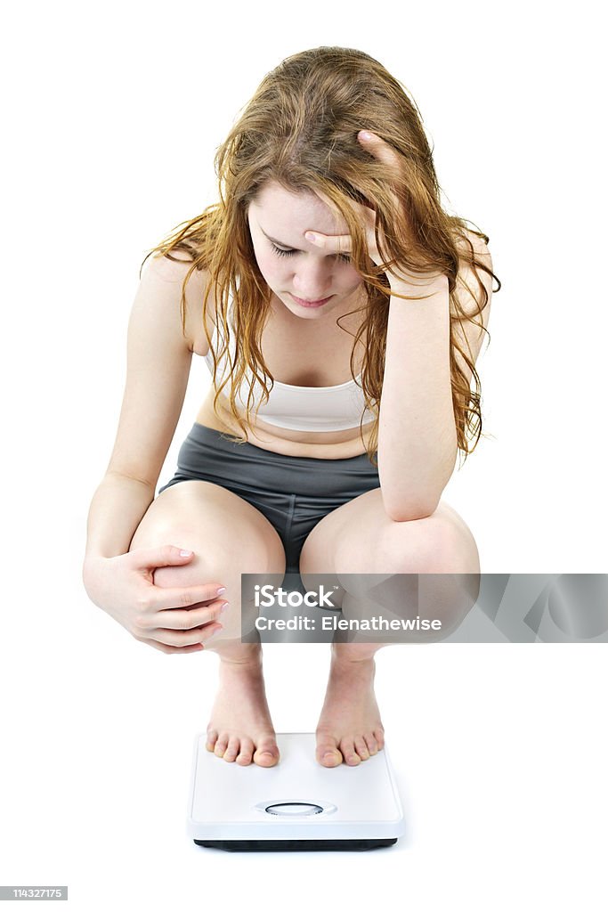 若い女の子お掛けに体重計 - 摂食障害のロイヤリティフリーストックフォト