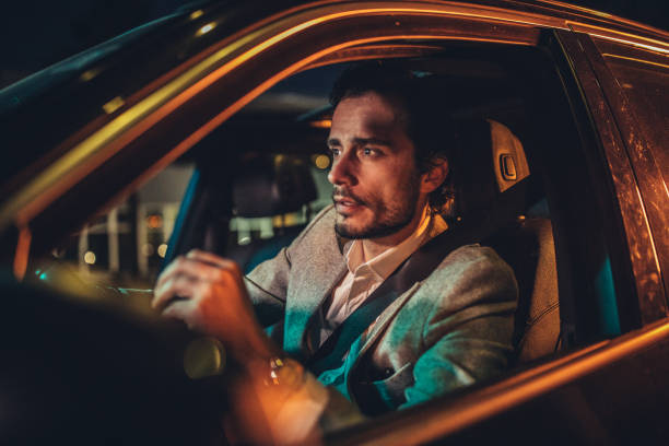 istock Guy driving a car in city at night 1143273423