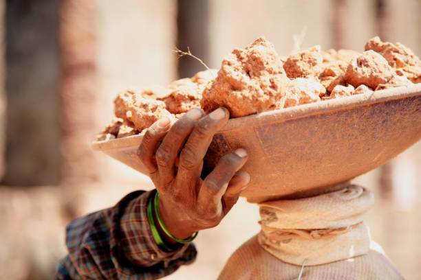 An Indian woman holds her hand with a load on her head