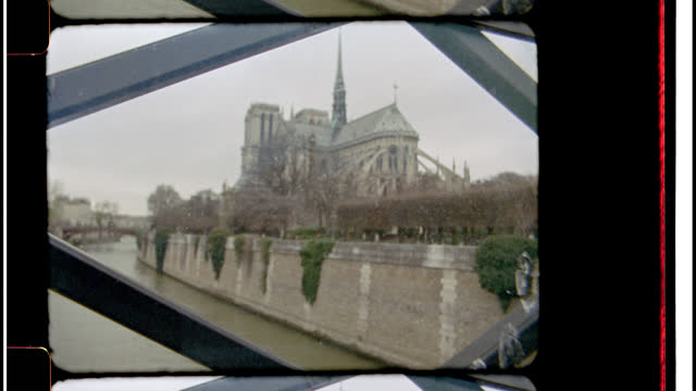 16mm Bolex Film footage of the Notre Dame Cathedral from a bridge along St. Joseph River in Paris, France.