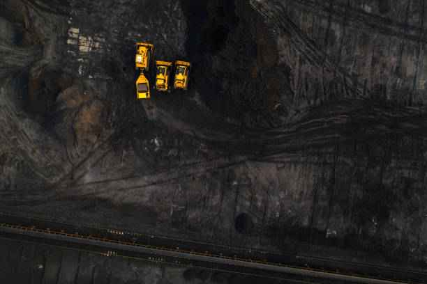 istock Top down view on yellow excavators in coal storage. 1143275476