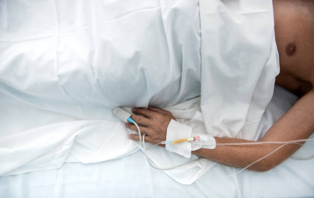 istock Patient lying in hospital bed under white sheets 1143275748