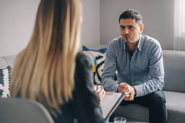 istock Young man having a home meeting with counsellor 1143276120