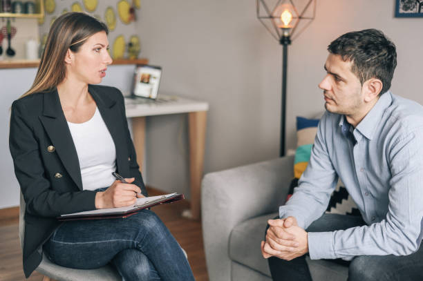 istock Young man having a home meeting with counsellor 1143276123