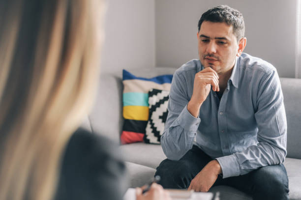 istock Young man having a home meeting with counsellor 1143276135