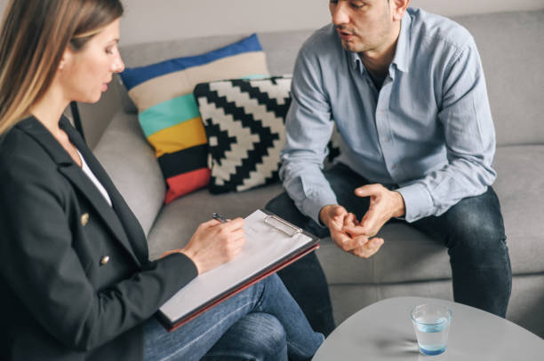 istock Young man having a home meeting with counsellor 1143276137