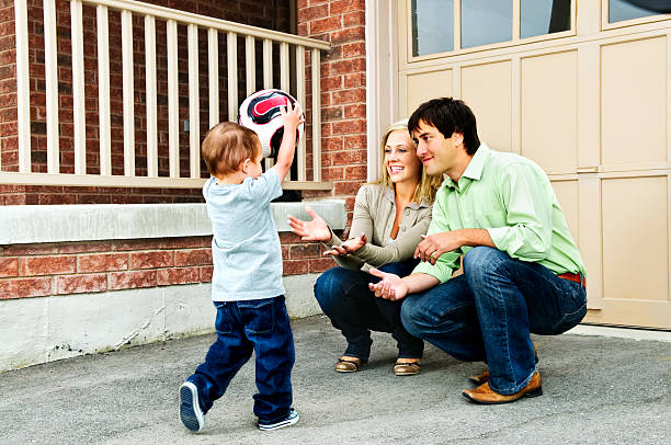 Lifestyle images of a cheerful hispanic family together. A father playing with his two daughters in a back yard on a sunny afternoon. Shot in Washington State, Pacific Northwest USA