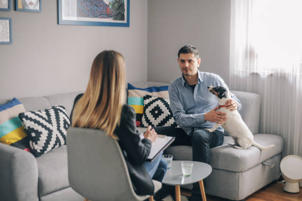 un joven que tiene una reunión en casa con el consejero - dog pets advice women fotografías e imágenes de stock