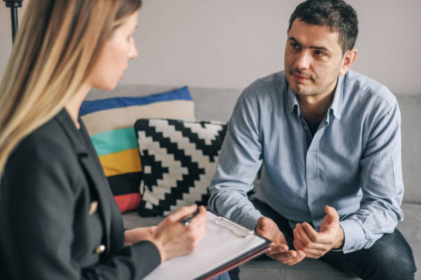 istock Young man having a home meeting with counsellor 1143276718