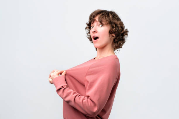 istock Curly young woman wants to make plastic surgery on breast 1143277047