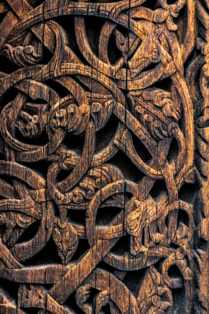Detailed pattern of ancient vikings in Norway Ornaments of ancient vikings on a wooden surface. External wooden wall carved decoration of medieval Stave church with viking motifs covered with tar. Detailed pattern of ancient vikings in Norway. carving craft product stock pictures, royalty-free photos & images