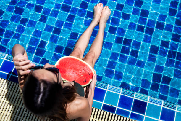 istock A women relaxing and holding watermelon on swiming pool. 1143280582
