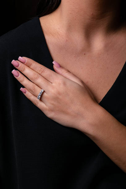 istock Womens silver diamonds ring with a fringe on finger, on a black background. 1143281413