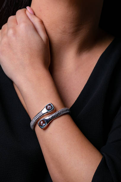 istock Womens silver braided bracelet with two stones at the end, dressed in hand. 1143281661