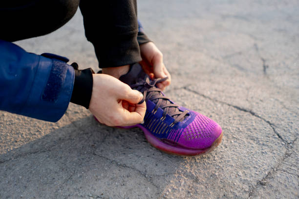 istock strong runner tie shoelaces before run on the asphalt b 1143281898