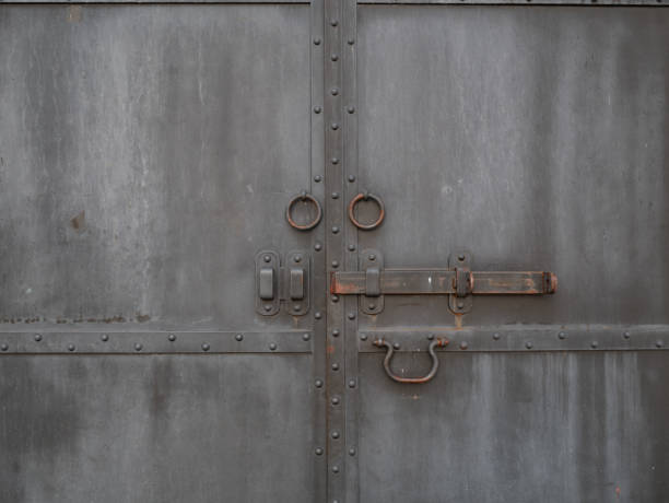 istock closed vintage retro black rusty metallic iron doors with bolt and round handles 1143282104
