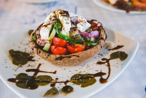 Traditional Santorini salad served in bread crust. Based on local products, including rusks, chlorotyri (fresh cheese), tomatoes, capers and caper leaves