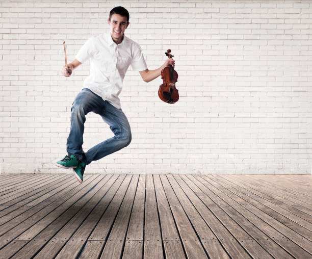 istock man holding a violin and jumping 1143285115