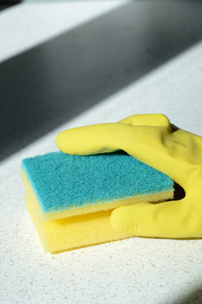 istock Hand in rubber glove washing surface lit by the sun. Spring cleaning 1143285141