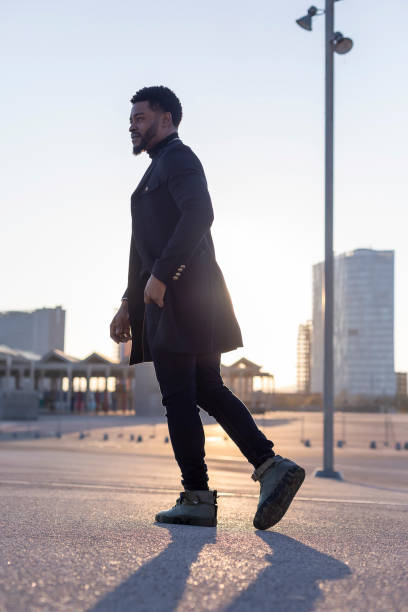istock Rear view of a black young bearded man walking outdoors while looking away 1143286841