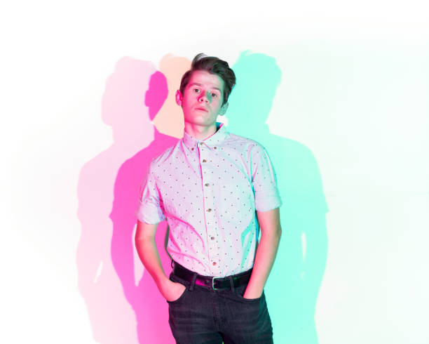 istock Handsome young man standing against white wall with colorful shadows 1143287710