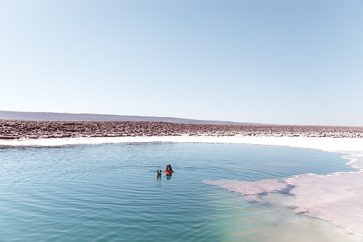 Woman bathing in beautiful turquoise salt lake in Atacama region in Chile