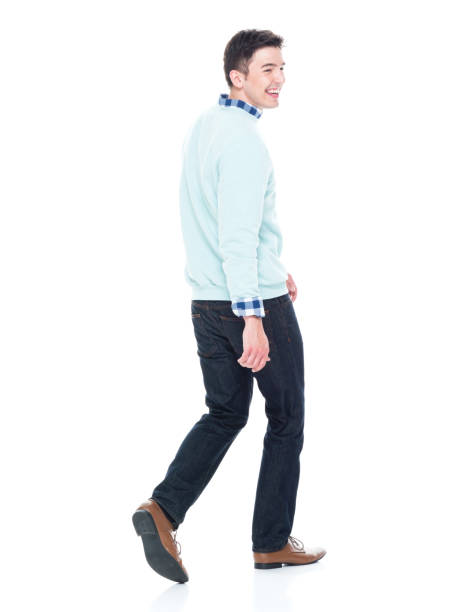 istock Handsome young man walking and looking behind, rear view. 1143289312