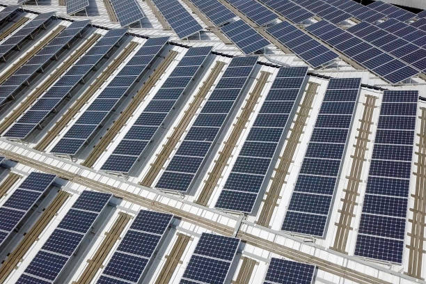 istock Solar panels spread across an industrial roof 1143293352