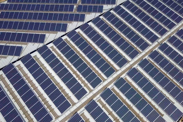 istock Solar panels spread across an industrial roof 1143294090