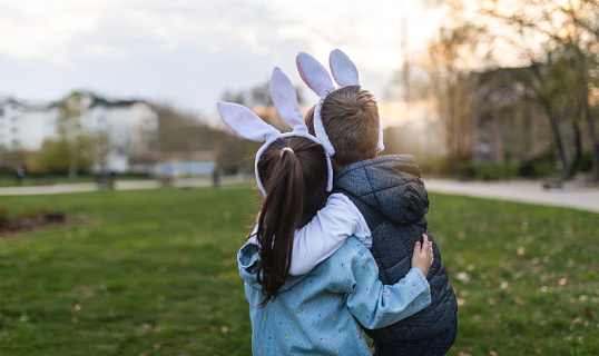 Cute and lovely siblings enjoying Easter together outdoors.