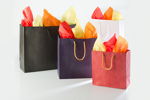 Shopping bags with color papers against a white background