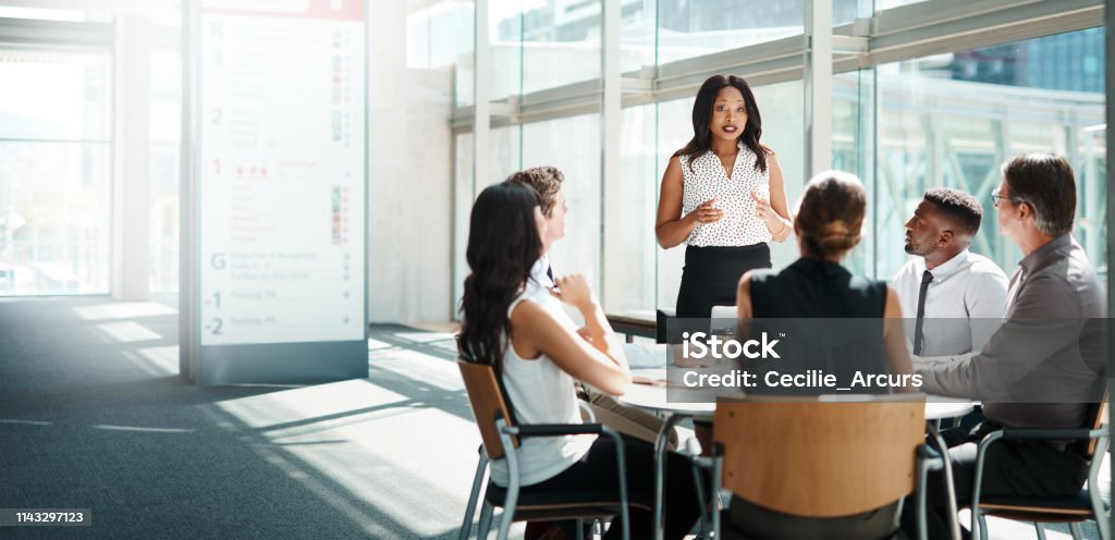 Be the leader when all others are following Shot of a group of businesspeople having a meeting in a modern office Multiracial Group Stock Photo