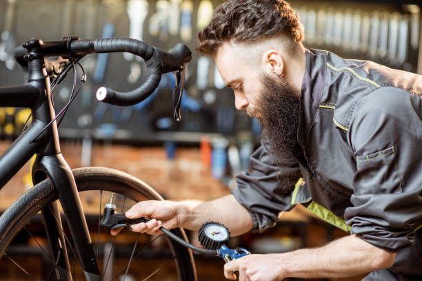 istock Repairman serving sports bicycle at the workshop 1143297400