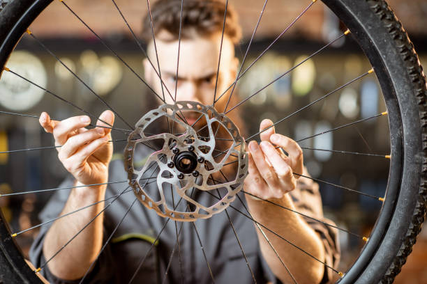 istock Repairman with bicycle wheel in the workshop 1143297516