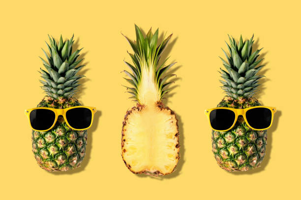 istock Fresh pineapples with sunglasses on yellow background. Creative suumer concept. 1143299451