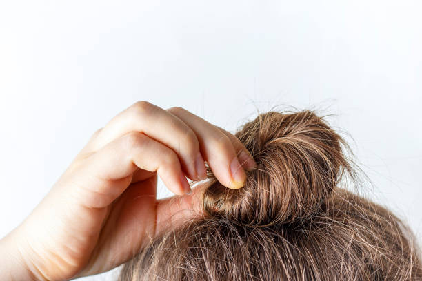 istock Female hand correct the bun on white background. Modern fast hairstyle. 1143302064