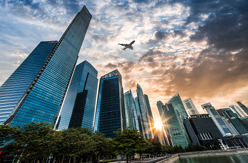 Airplane flying over the financial district in Singapdre City at sunset