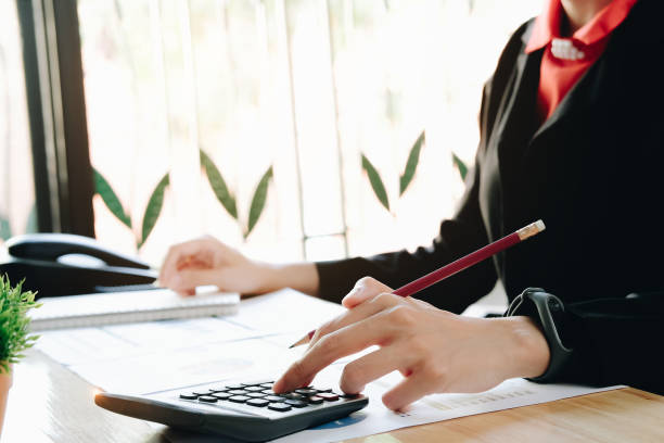 istock Businesswoman pen pointing graph chart in this mount and use calculator for Plans to improve quality next month. 1143306532