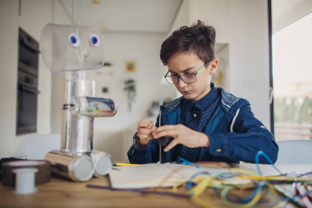 istock Boy making robot toy of recycling material 1143308158