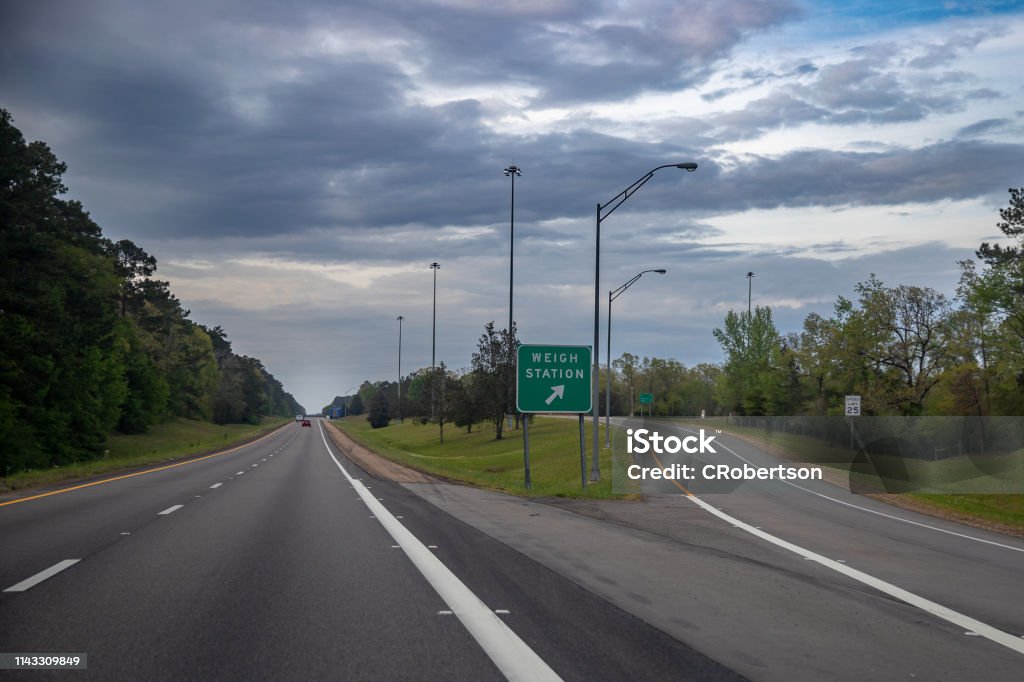 Weigh station exit for freight trucks on the interstate Weigh Station exit sign for trucks transporting freight, to insure the vehicle is within regulations and following the law Weight Scale Stock Photo