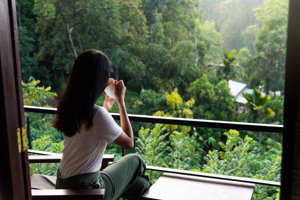 Woman having a cup of tea on the balcony Woman having a cup of tea on the balcony alone ella sri lanka stock pictures, royalty-free photos & images