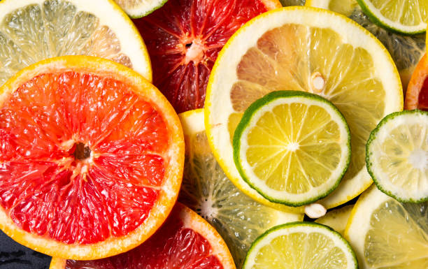 istock Sliced citrus fruits on a dark background pattern 1143317885