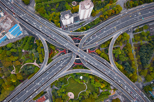 Aerial view of highway junctions shape letter x cross at noon. Bridges, roads, or streets in transportation concept. Structure shapes of architecture in urban city, Shanghai Downtown, China.
