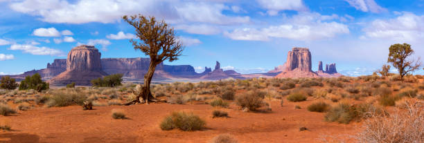 Monument Valley Panoramic of buttes in Monument Valley, Arizona, under a nicely clouded sky butte rocky outcrop photos stock pictures, royalty-free photos & images
