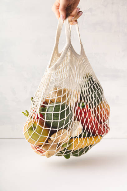 istock woman's hand holding a bag of mixed fruit and vegetables 1143322997